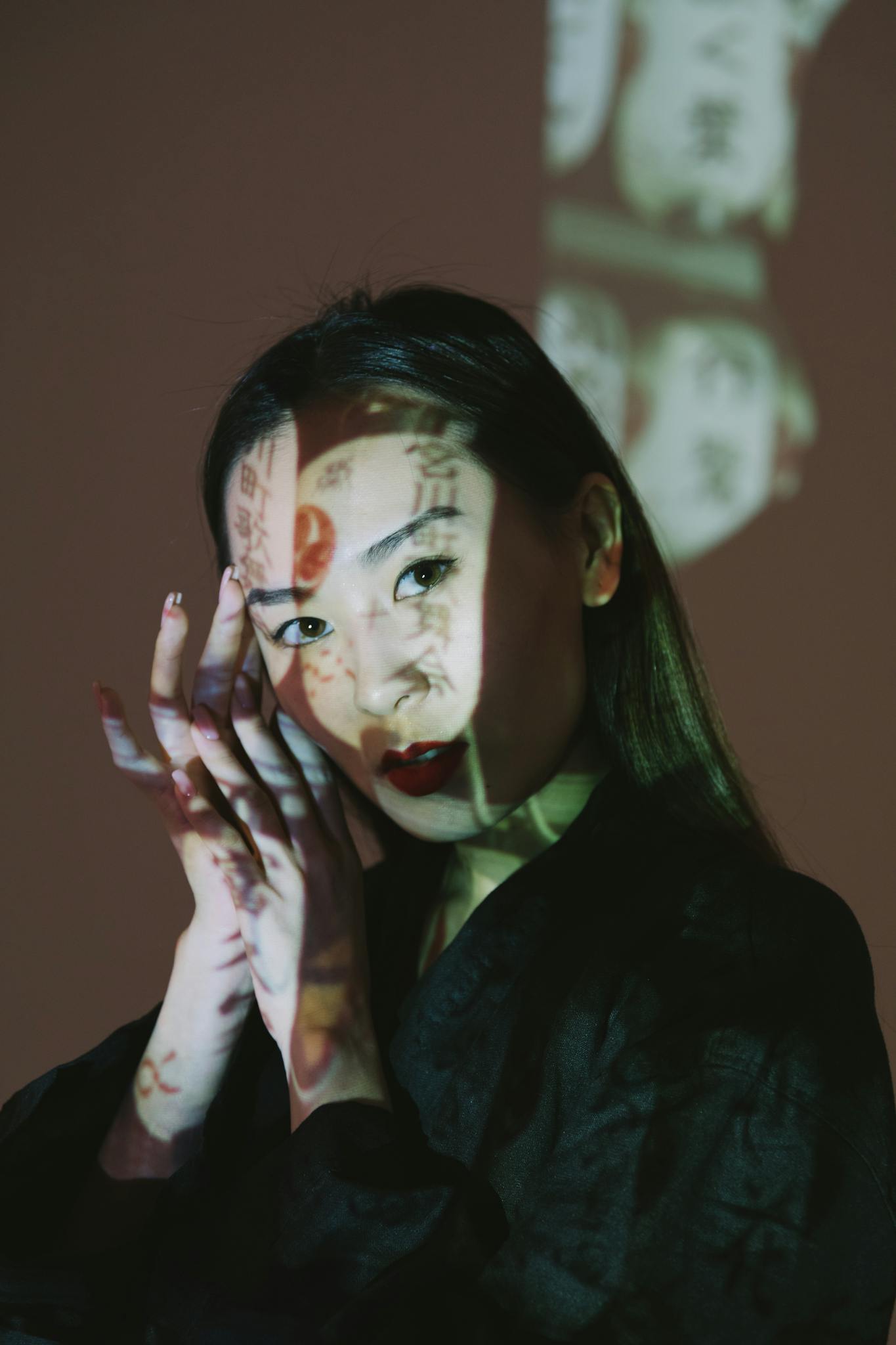 Creative portrait of a young woman with artistic text projections on her face.